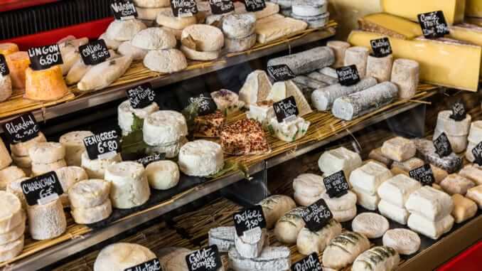 Different cheeses on the counter of a small store at the Aligre Market. Paris, France Different cheeses on the counter of a small store at the Aligre Market. Paris, France