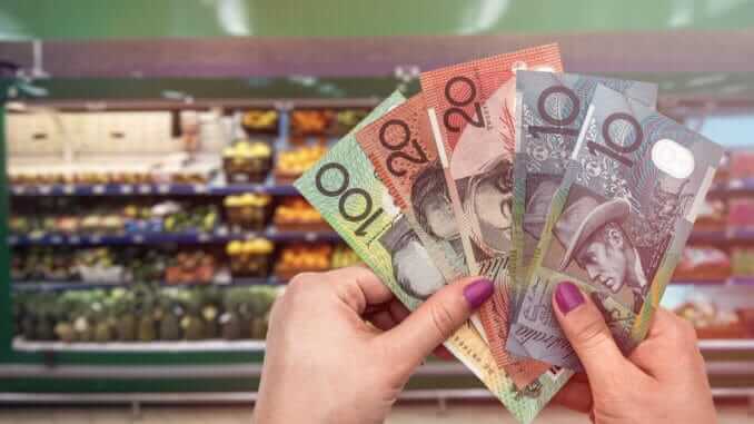 Australia fresh fruits and vegetables, hand with dollars Australia fresh fruits and vegetables, hand with dollars