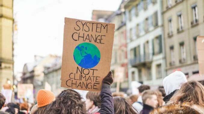Group of demonstrators on road, young people fight for climate change - Global warming and enviroment concept - Focus on banner Group of demonstrators on road, young people fight for climate change - Global warming and enviroment concept - Focus on banner