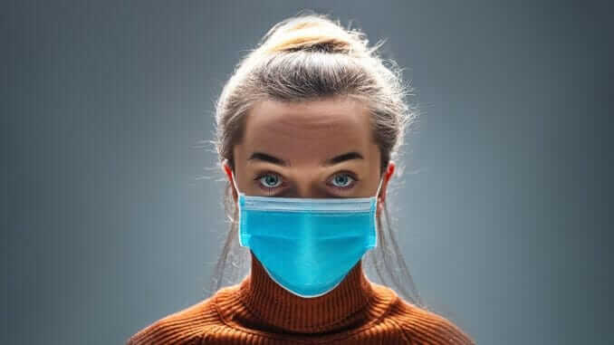 Woman wearing blue medical protective mask to health protection from influenza virus, epidemic and infectious diseases Woman wearing blue medical protective mask to health protection from influenza virus, epidemic and infectious diseases