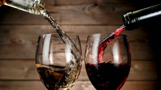 Red and white wine pouring on wood background Red and white wine pouring on wood background