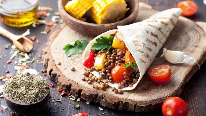 Vegan tortilla wrap, roll with grilled vegetabes, lentil, corn cob.