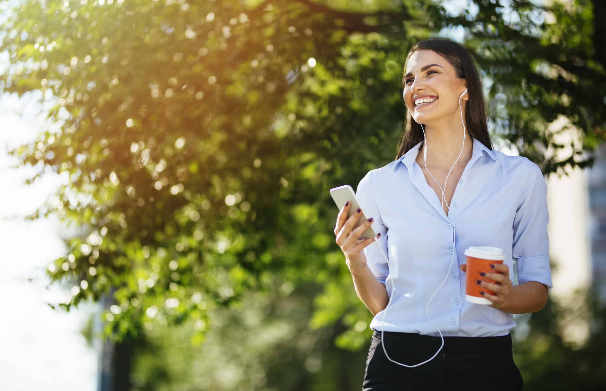 Young businesswoman in city park on a coffee break