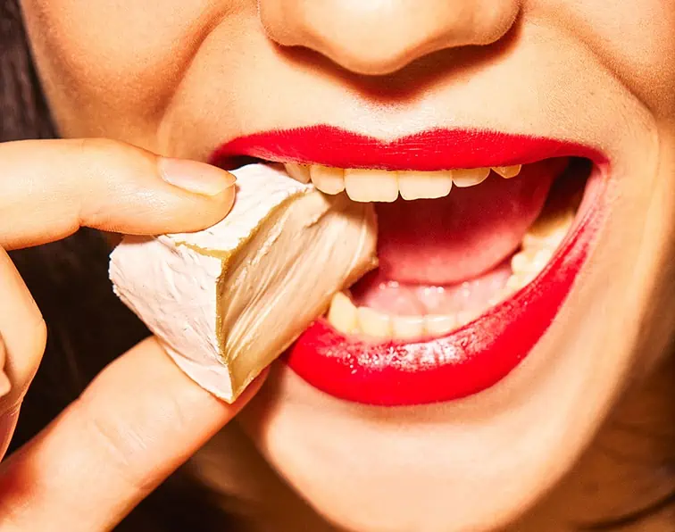 Close up of woman eating Mommus Camembert