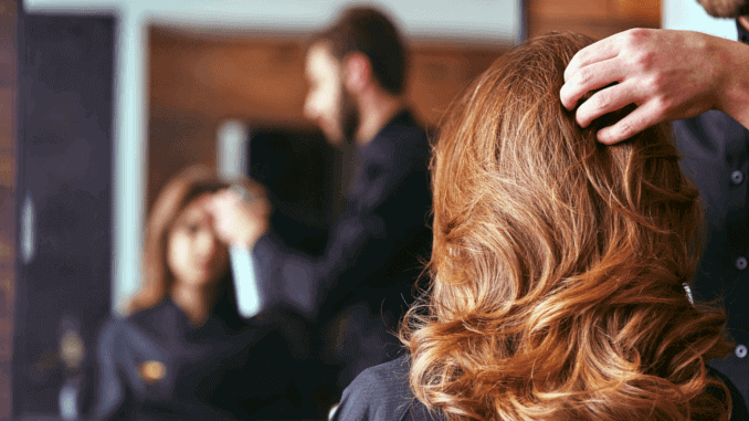 vegane Haarpflege von IGK Frau sitzt beim Friseur für Styling