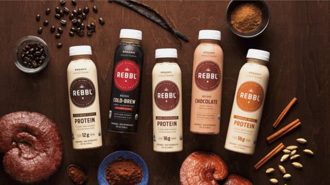 REBBL vegane adaptogene Getränke REBBL adaptogene vegane Getränke auf braunem Tisch umringt von Zutaten