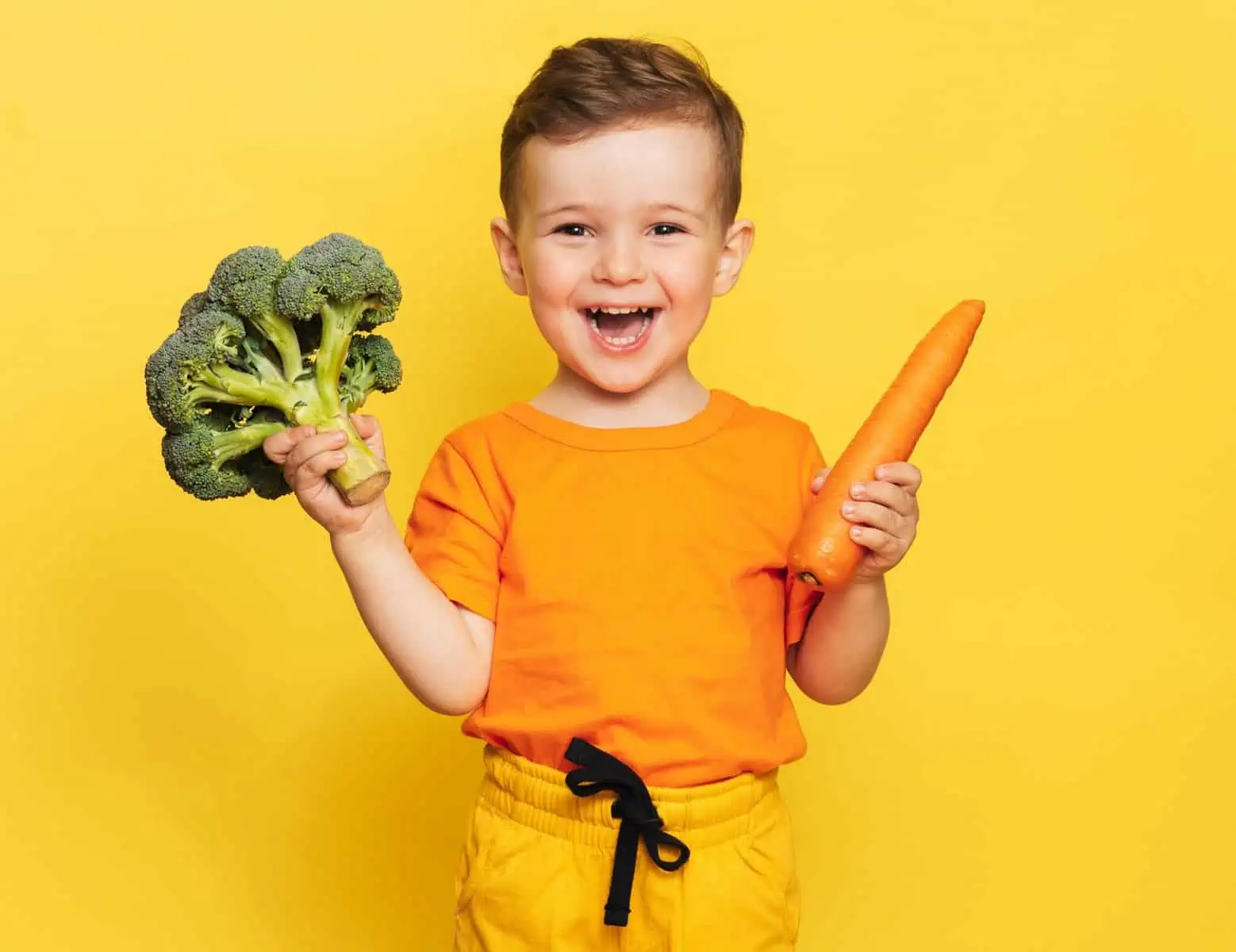 small child with carrot and broccoli