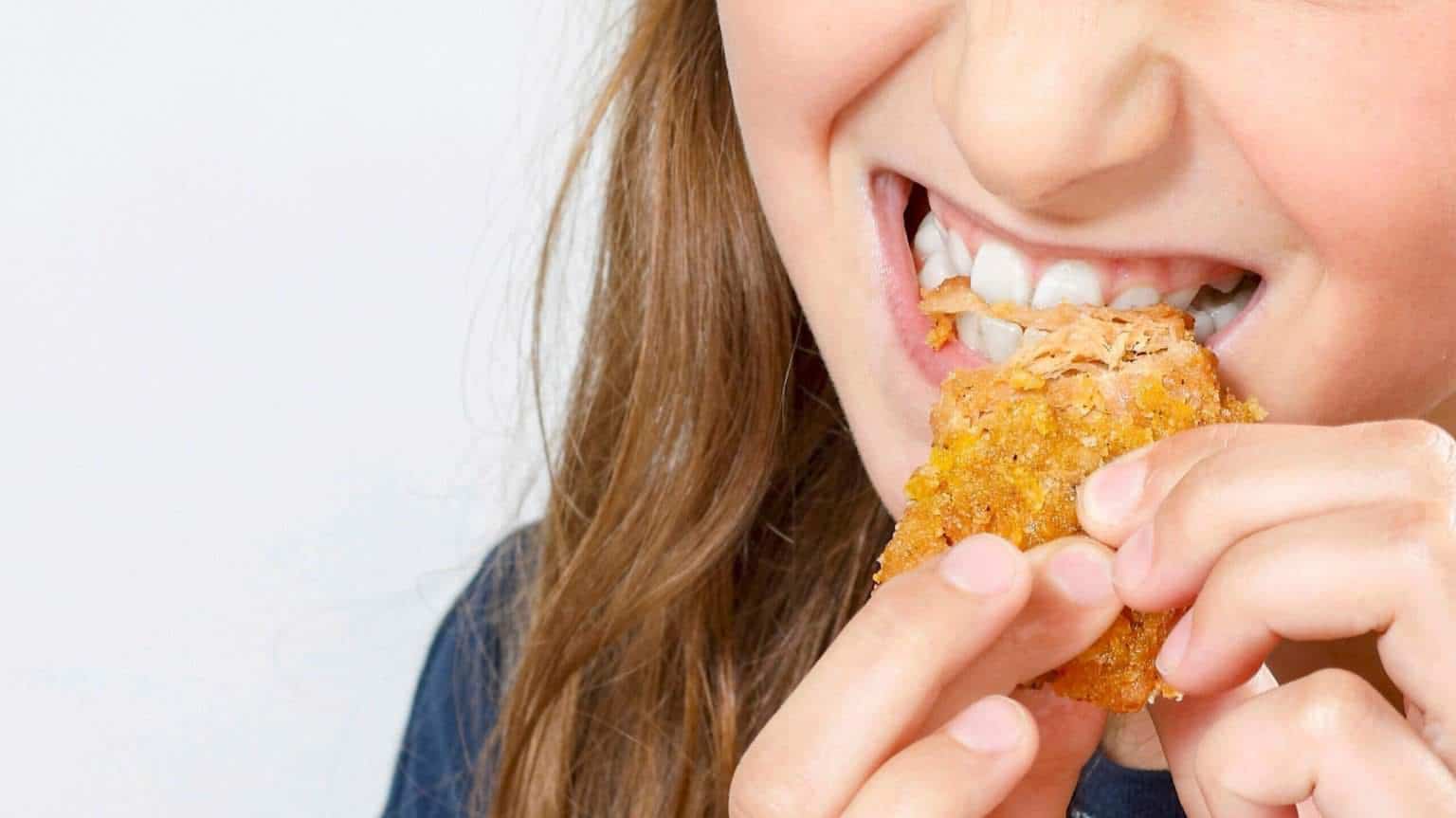 close up woman chewing Dévore food NUGGS